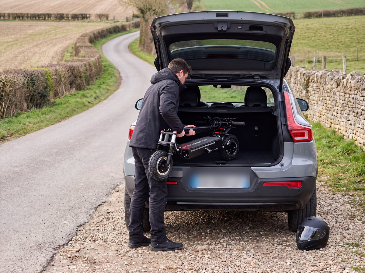 Adulte rangeant la trottinette électrique J30MAX pliée dans le coffre d'un SUV