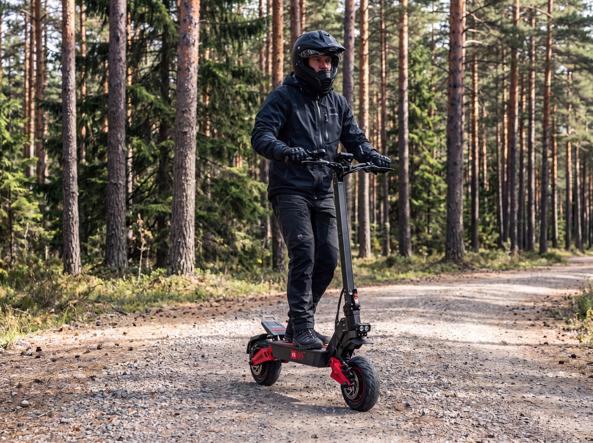 Rider casqué conduisant la trottinette électrique tout-terrain 6000W sur un chemin forestier privé